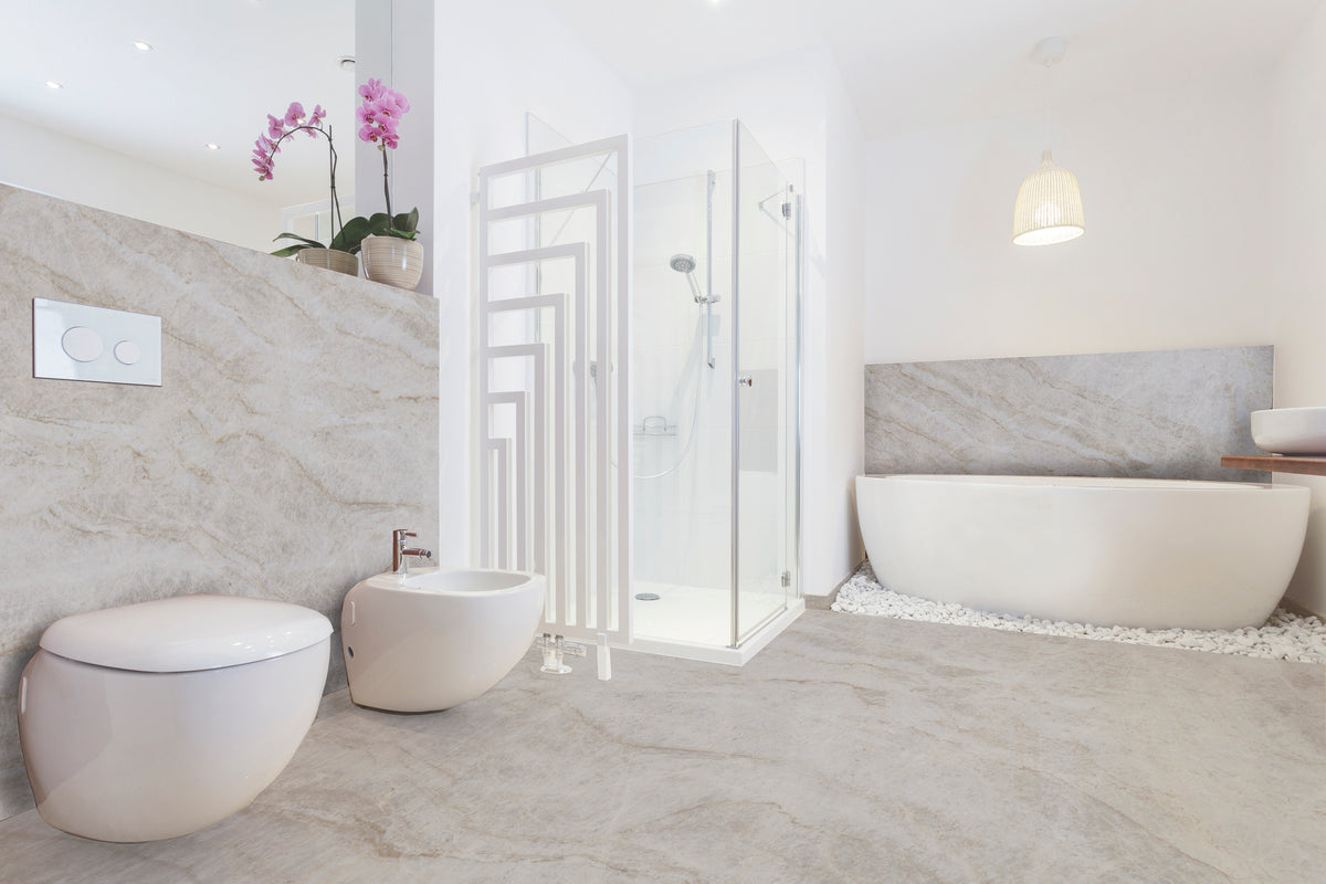 Luxurious bathroom featuring Quartze Taj Mahal marble-look tiles, white toilet, bidet, glass shower, and freestanding tub.