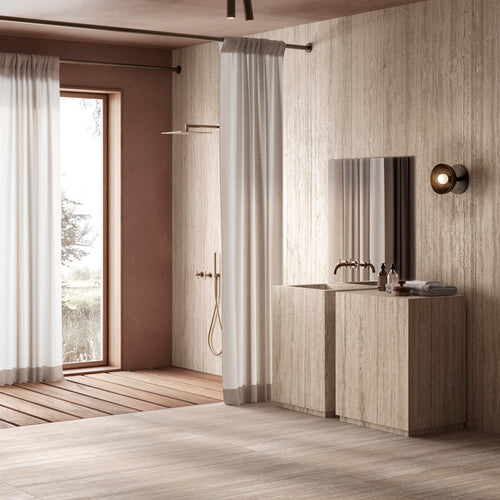 Warm-toned restroom interior featuring Travertine Veincut 24X48 Beige Matte tile throughout, accented by soft floor shadows.