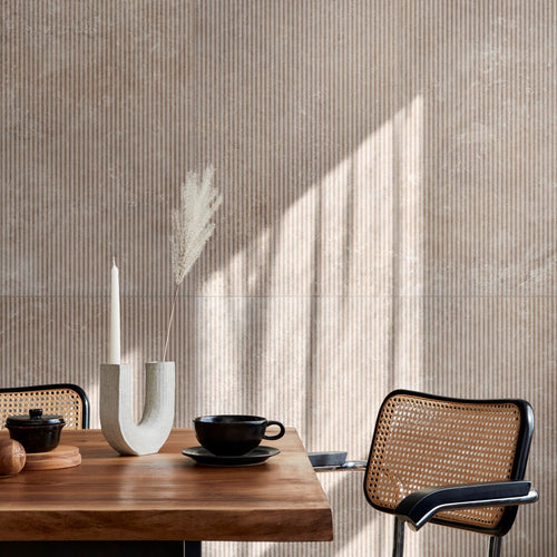 Soft daylight falls across a styled seating nook, with Travertine Veincut Canetto 3D Beige Matte tile creating a warm backdrop.