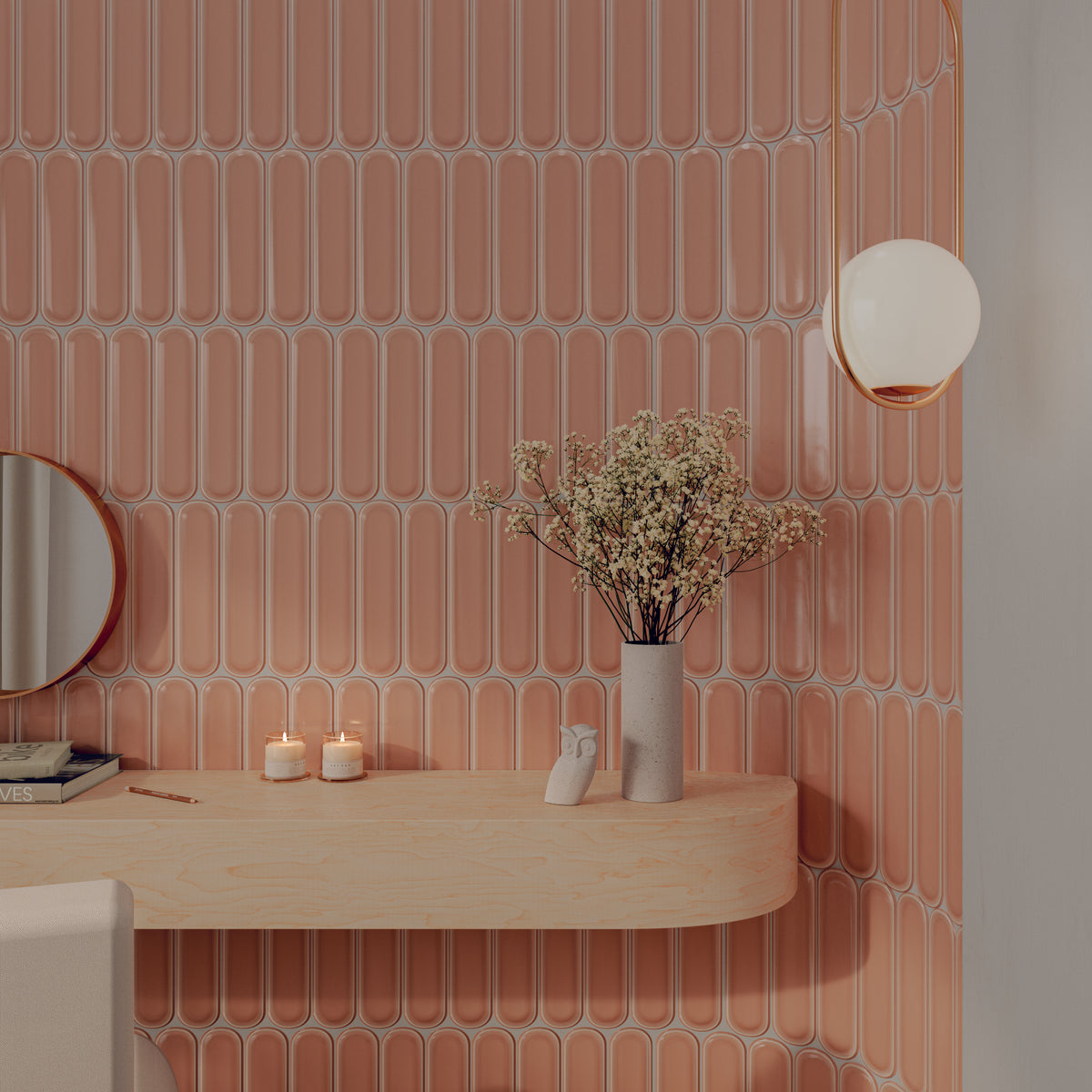Modern vanity with salmon-pink vertical tiles, floating wood shelf with decorative items, and a brass wall lamp.