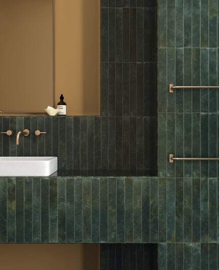 Bali Isle Of Pines 2x16 glossy ceramic tile installed on a bathroom wall with deep green variation